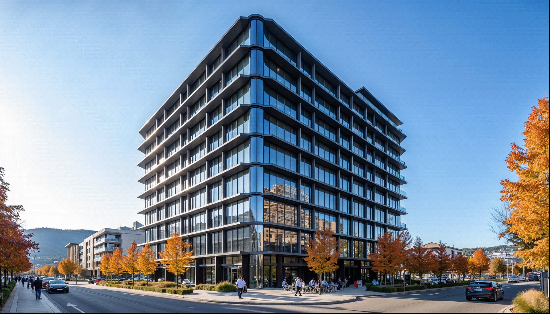 Modern office building with glass facade and multiple doors surrounded by autumn trees on a city street