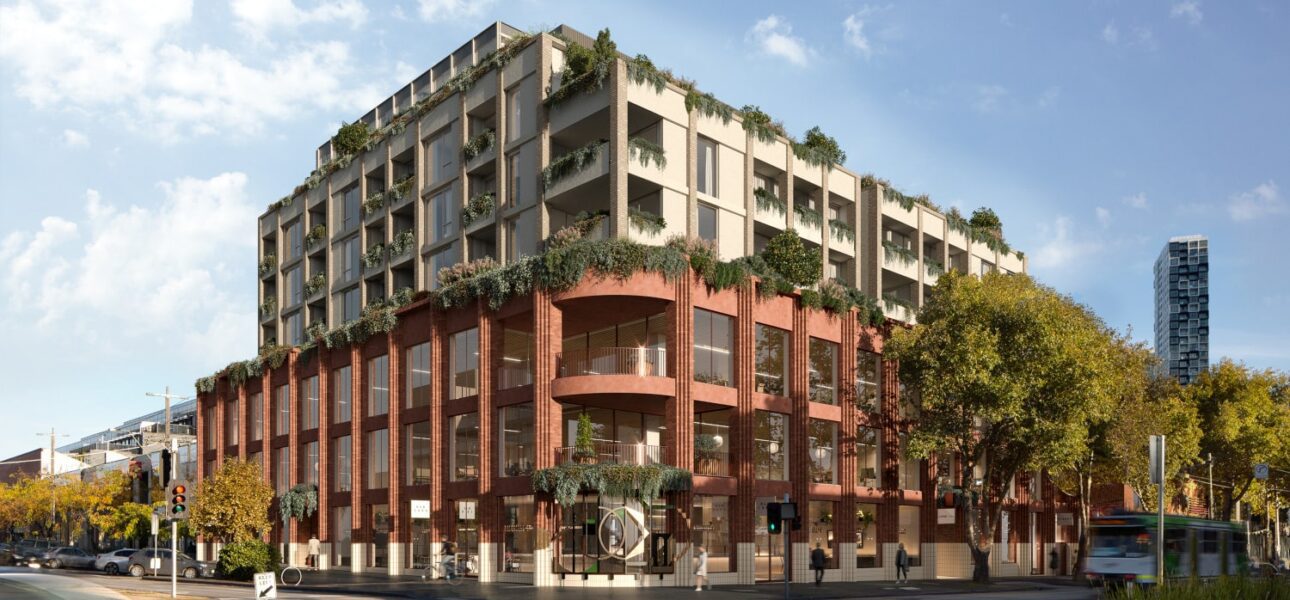 Modern urban building with greenery on the facade located at a busy city intersection under a blue sky